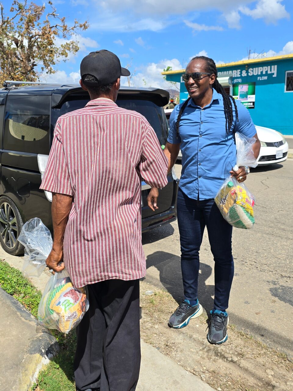 Minister Terrelonge presents a care package to a resident in Lacovia, St. Elizabeth, as part of the Government’s ongoing emergency relief distribution.